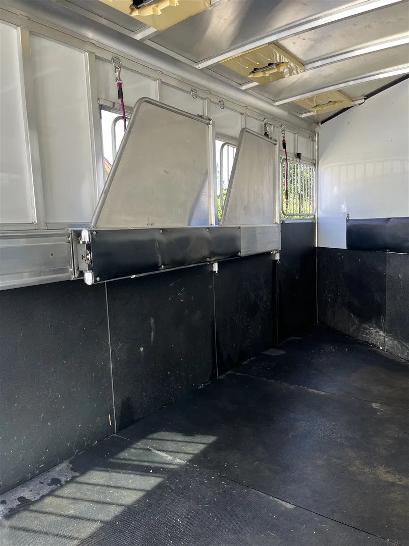 2013 Sundowner Sportsman 3 Horse Trailer – Extra-Large Tack Room – Looking through the horse area stalls showing rubber mats and dividers folded back