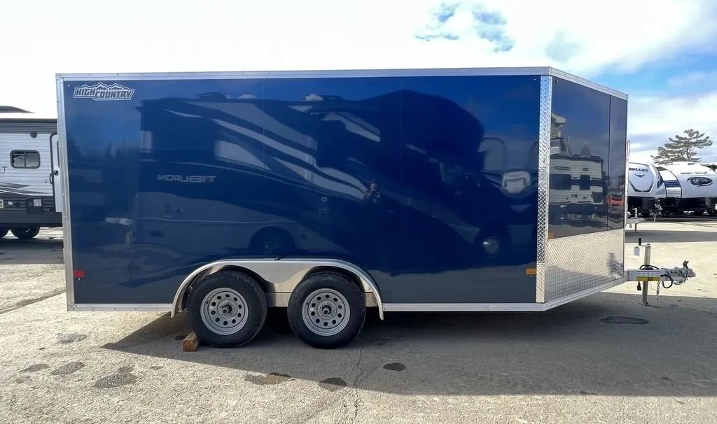 2023 High Country 14 ft Trailer – Blue, Drive-Through – Full side profile of the blue dual-axle trailer showing the smooth exterior panels