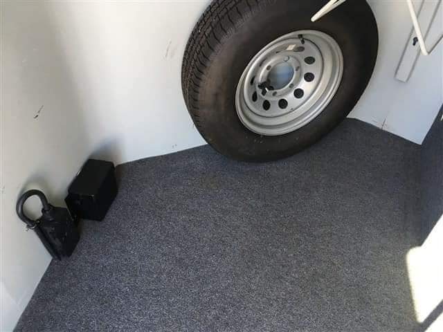 2007 Hawk 2 Horse Bumper Pull Trailer – Side Ramp – A spare tire and battery box stored on the carpeted floor of the trailer