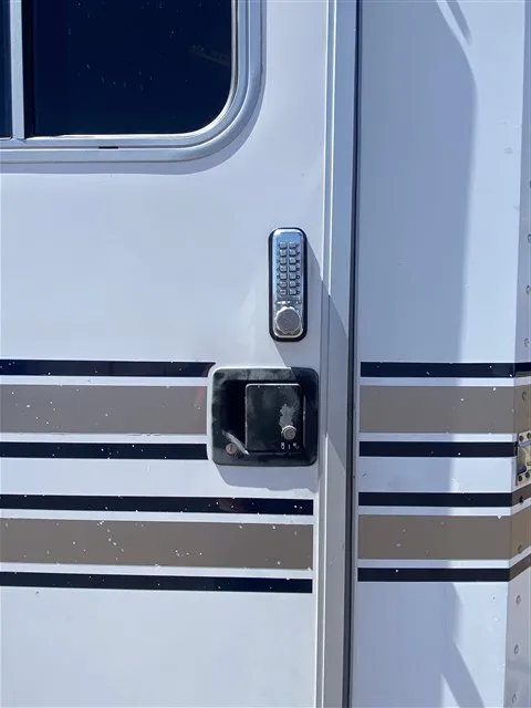 2000 Sooner 4 Horse Bumper Pull – Dressing Room, Awning – Close-up of the door handle and a digital keypad lock