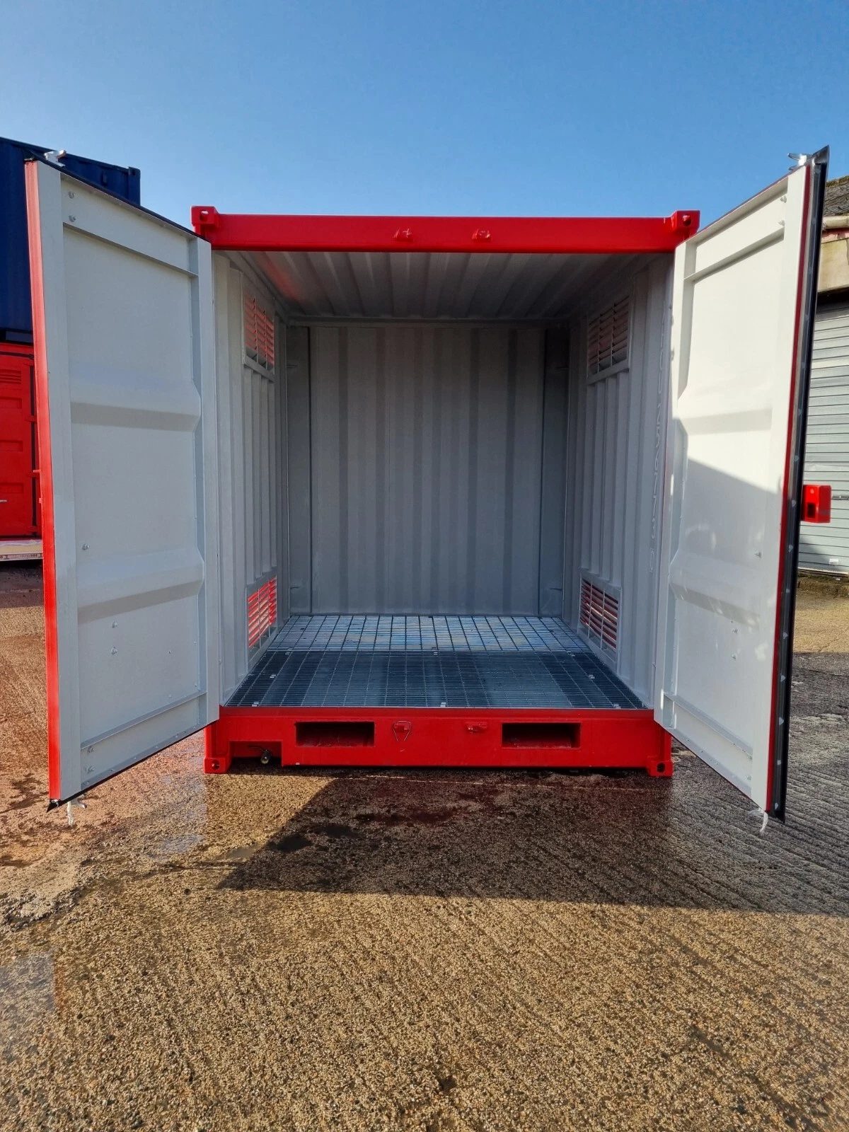 9ft Hazardous Goods Storage Container – Integrated Spill Sump – open container doors revealing empty ventilated interior and grated floor