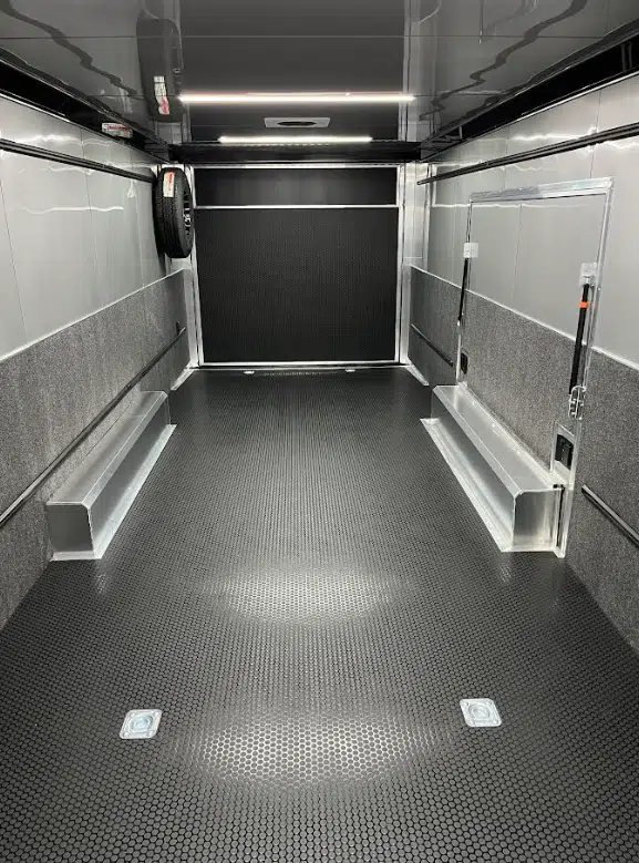 2026 ATC 28 ft Car Trailer – Silverfrost, LifeTrac – Interior view facing the rear ramp door with wall-mounted spare tire and tie-downs