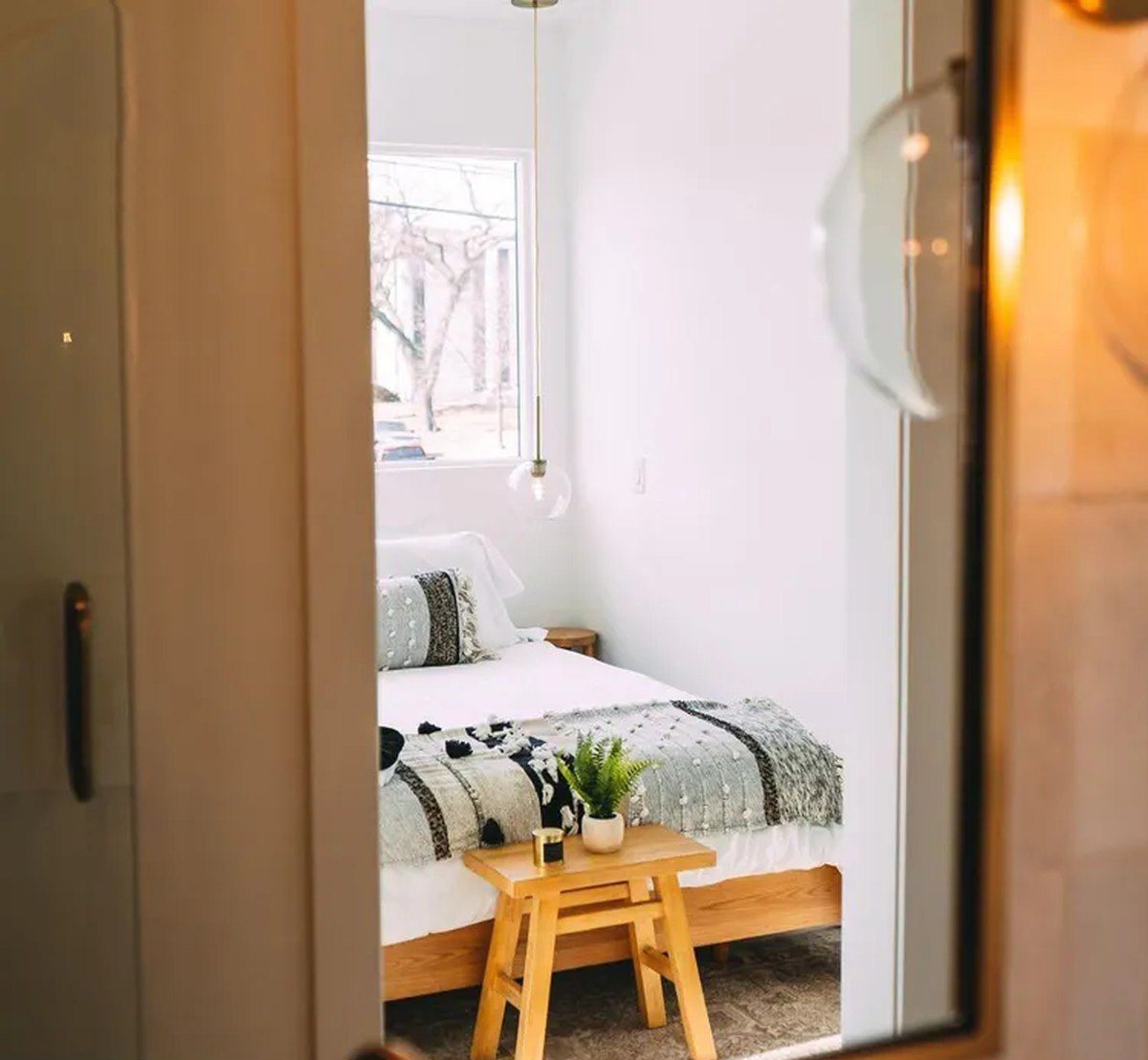 3-Bedroom Duplex Container Home – Rooftop Deck – Upper level bedroom with hardwood-look flooring and soft natural light