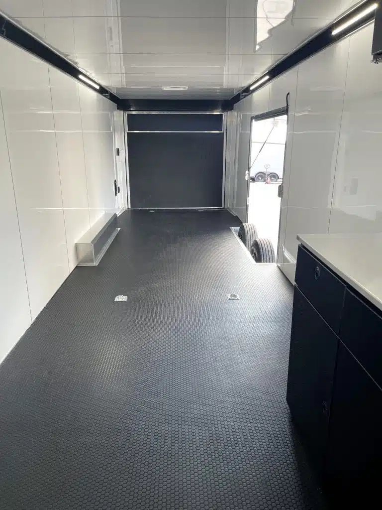 2026 ATC 40 ft Gooseneck – Black Trim – Interior view facing the rear ramp door with black flooring and side door