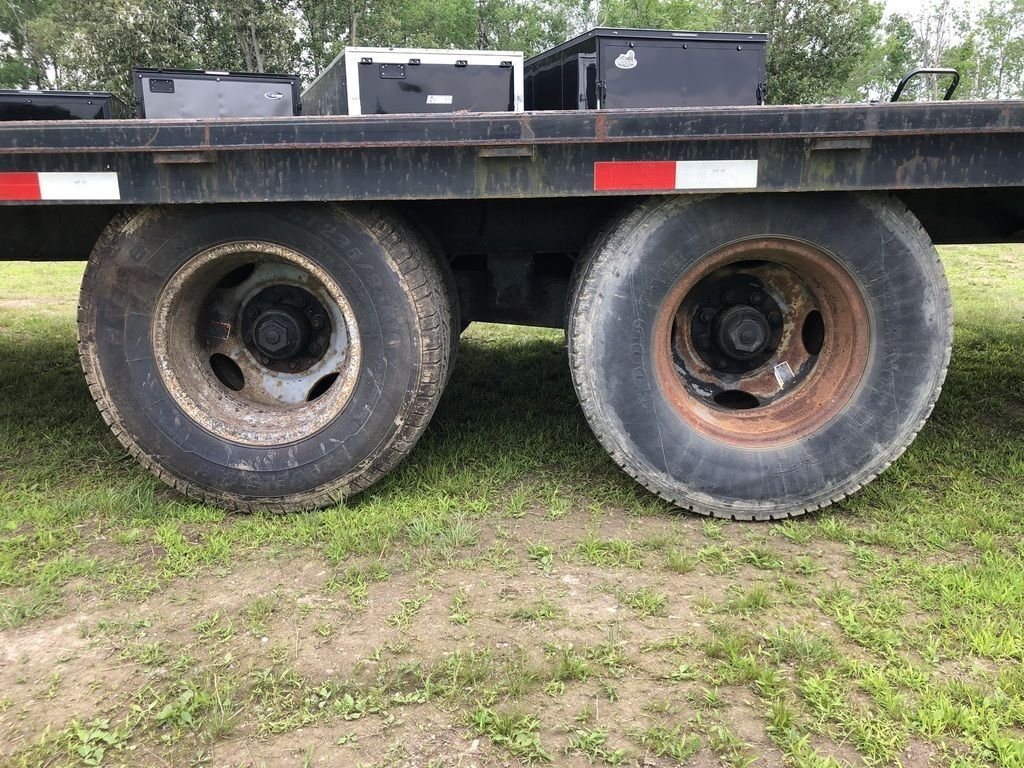 2002 Kaufman 40 ft Equipment Trailer – Toolbox – Close-up of dual wheels and tires under the black trailer frame