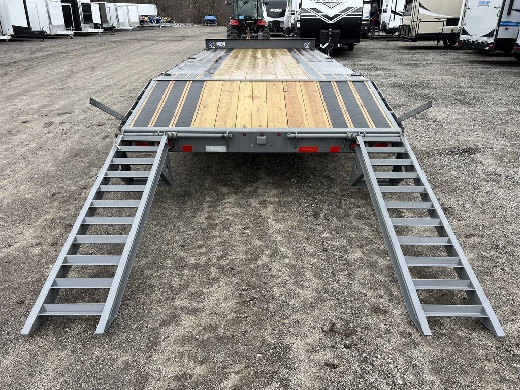 2024 Diamond C Deckover Equipment Trailer – Cement Gray – Rear view of the trailer with two metal loading ramps extended to the ground