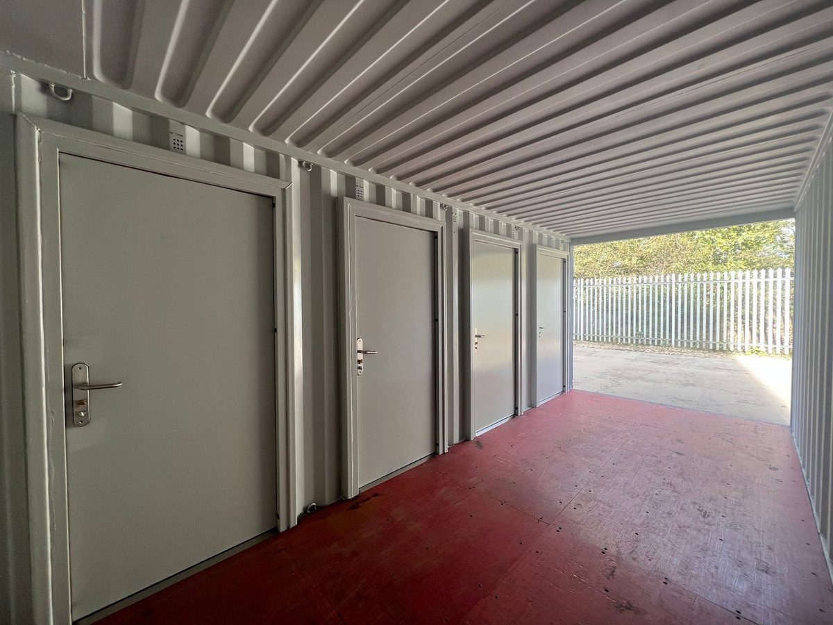 20ft New Shipping Container – Four-Door Storage Configuration – empty container corridor with four closed storage compartment doors