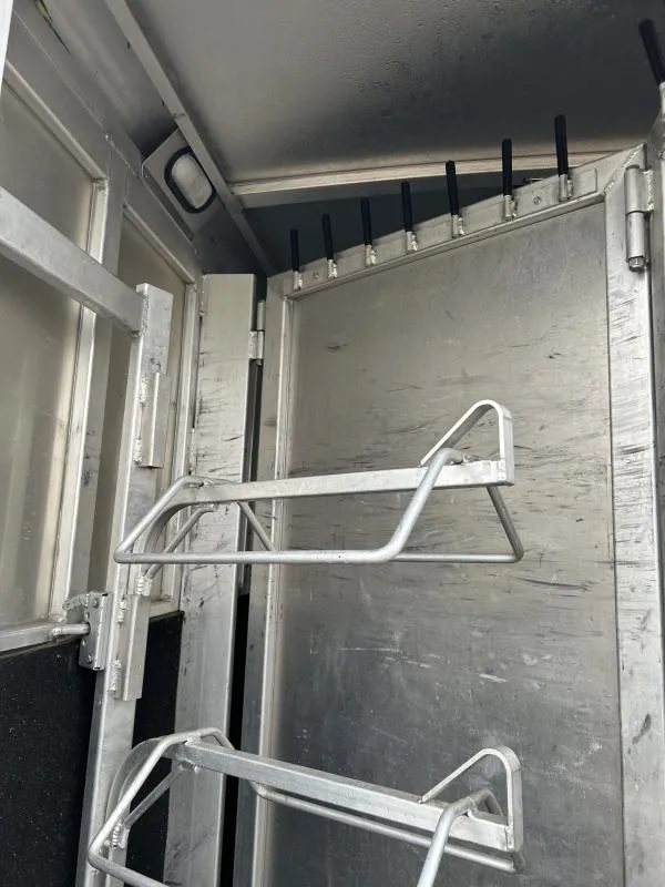 2002 Silverado 3 Horse Gooseneck Trailer – Wood Interior – Close-up of metal saddle racks and bridle hooks in the tack area