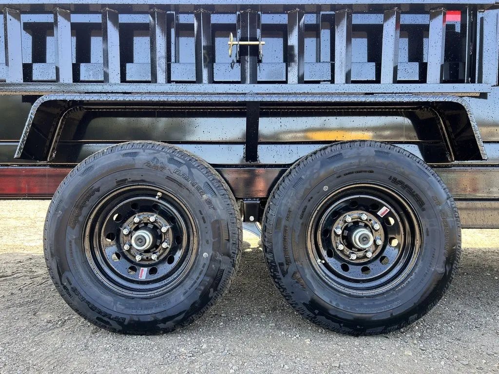 2024 Griffin Trailers 16 ft Dump Trailer – Telescopic – A close-up view of the dual axles and black wheels with tires