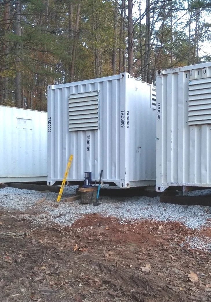 40ft High Cube Container Office – Storage Racking, Side Access – white containers with large ventilation louvers beside wooded area