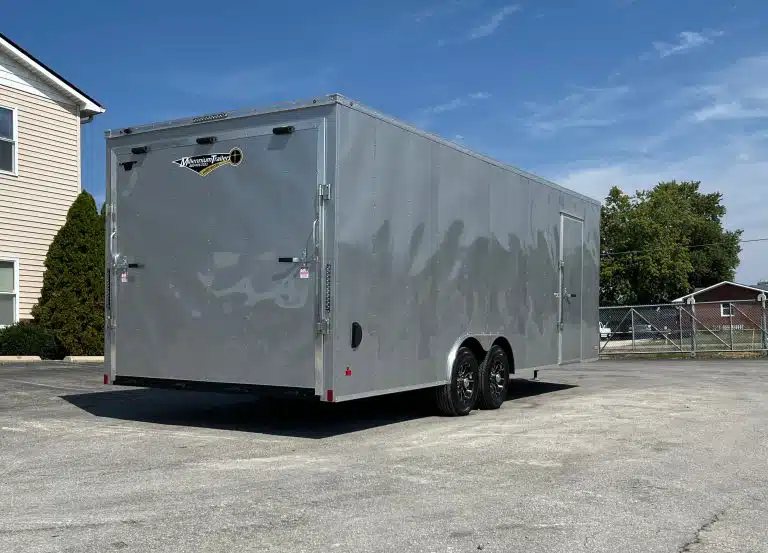 2026 Millennium 24 ft Car Hauler – Silver Hero – Rear three-quarter view showing the closed ramp door and side profile of the trailer