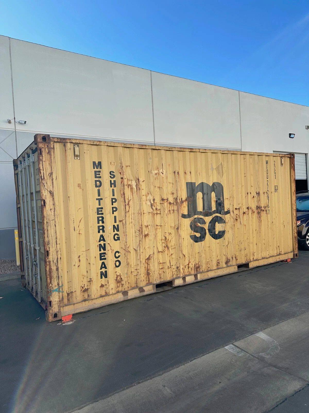 20ft Used Shipping Container – Yellow/Gold, Double Cargo Doors – Three-quarter exterior view of weathered yellow container with closed doors