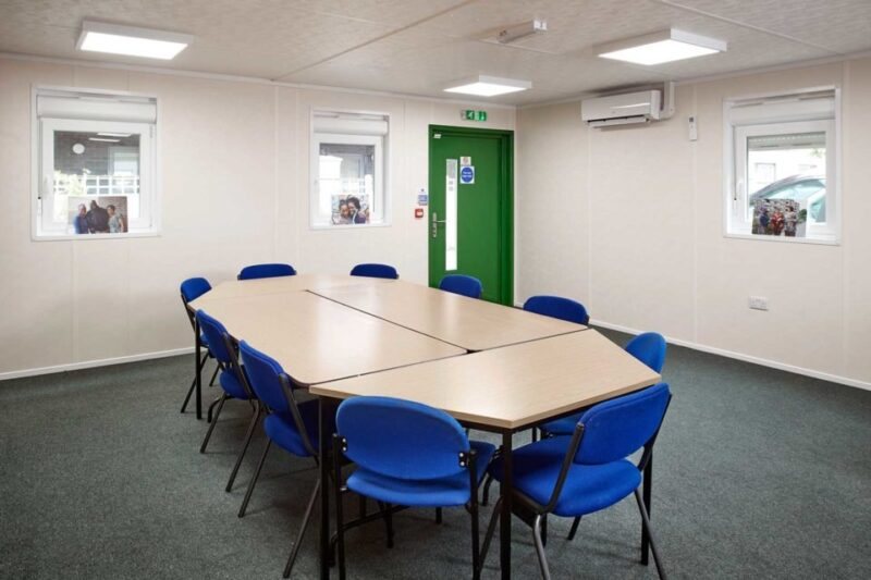 32 × 30 ft Modular Office – Green, 3 Bay – Conference room featuring a large modular table and several blue office chairs