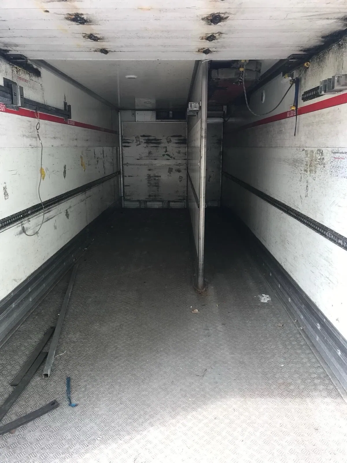 27ft–45ft Used Refrigerated Containers – Chiller & Freezer – worn refrigerated container interior with central partition and metal floor