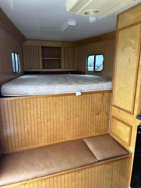 2004 Hart 3 Horse Gooseneck Trailer – Weekender Living Quarters – Sleeping area with a mattress and wood paneled bench seating