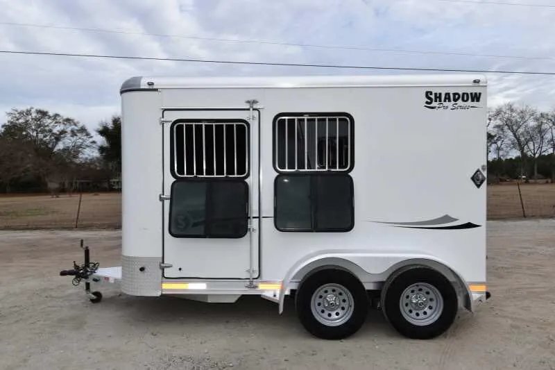 2016 Shadow 2HBP 2 Horse Bumper Pull Trailer – Aluminum – Left side of white horse trailer with closed windows and tandem axles