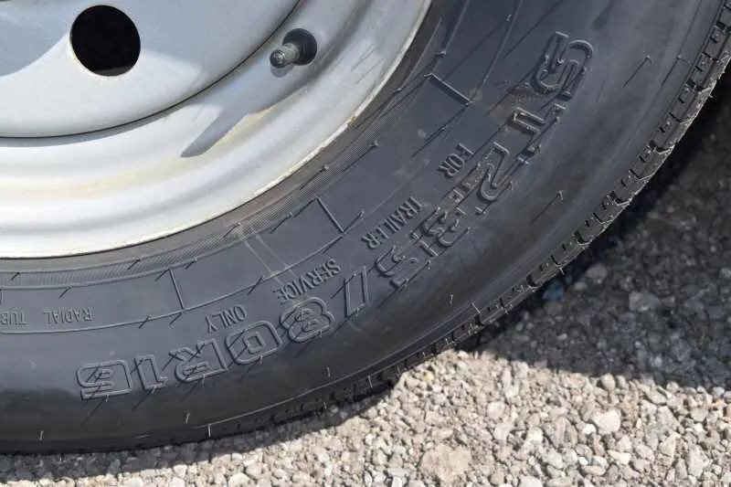 2014 Sundowner 2 Horse Gooseneck Trailer – Electric Jack – Close up of the tire tread and size markings on the black rubber