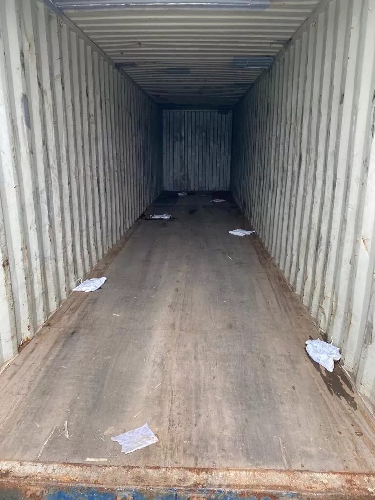 40ft Used Shipping Container – Standard Dry Storage – empty container interior with worn wooden floor and scattered paper