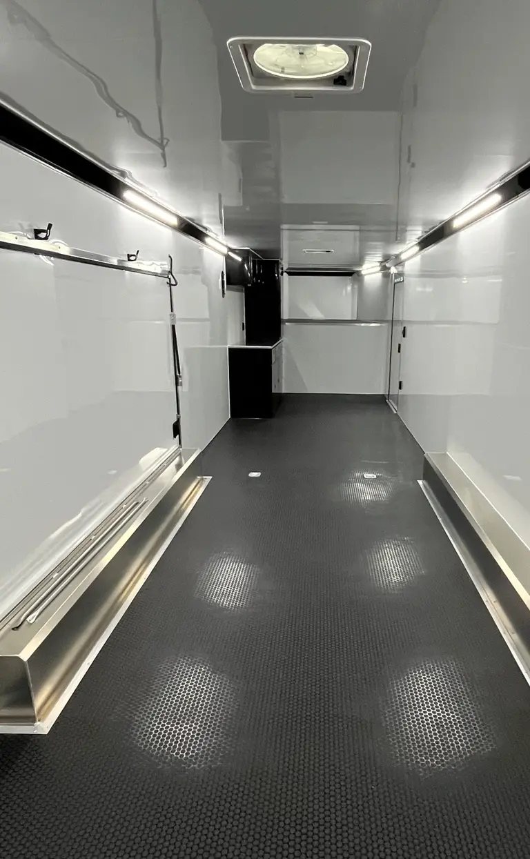 2025 ATC 44 ft Car Hauler – Premium Escape Door – Interior view showing white walls, black coin flooring, and overhead lighting