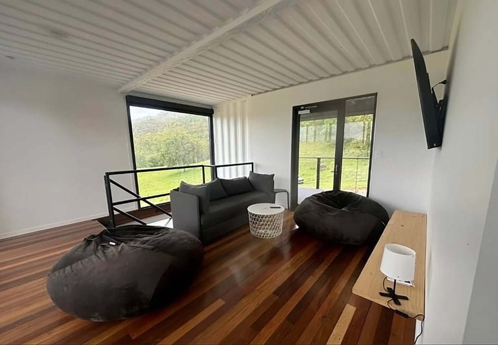 3-Bedroom Two-Story Container Home – Upper Terrace & Patio – Second living zone upstairs opens straight onto the terrace through sliding glass doors