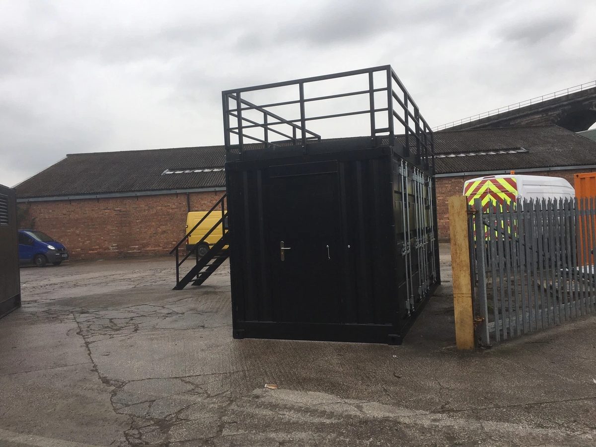 20ft Converted Shipping Container – Serving Hatches and Roof Deck – Black converted container with rooftop railings and exterior stairs