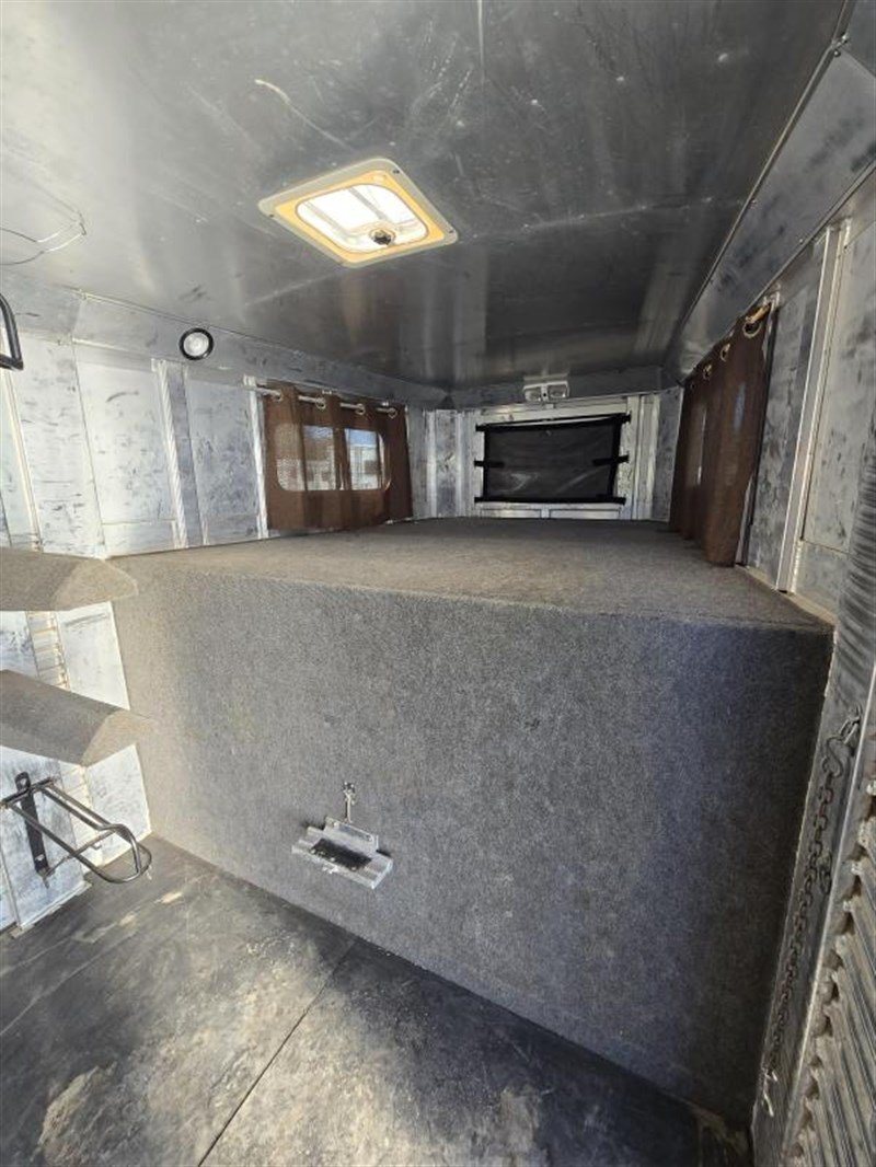 2006 C&C 4 Horse Gooseneck Trailer – Dual Hay Racks – The elevated gooseneck area inside the tack room with carpet and windows