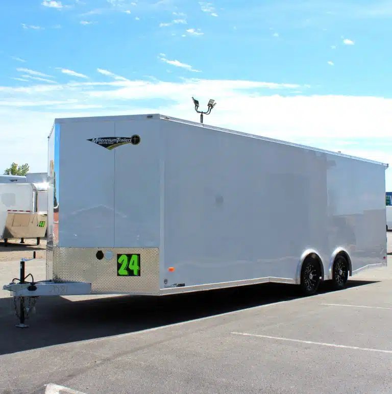 2026 Millennium 24 ft Car Hauler – White Blaze – A three-quarter exterior view of a white enclosed trailer under a blue sky