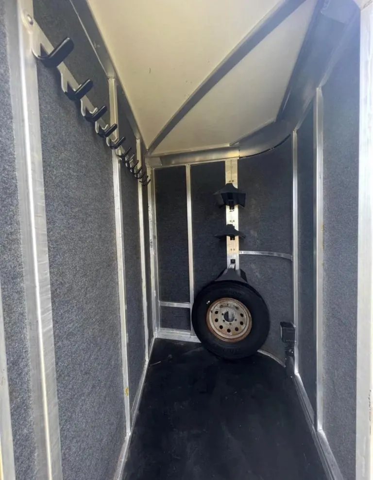 2013 Cimarron 3 Horse Bumper Pull – Aluminum, Dressing Room – Interior of the tack room featuring bridle hooks and spare tire
