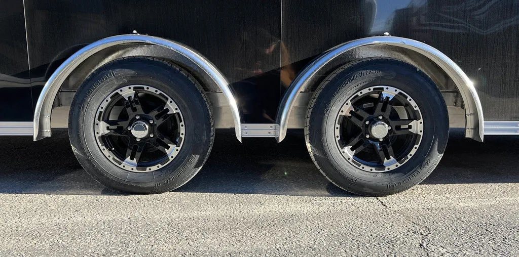 2024 Sno Pro 22 ft Snowmobile Trailer – Extra Height – Close up of the tandem wheels with black and silver rims and aluminum fenders