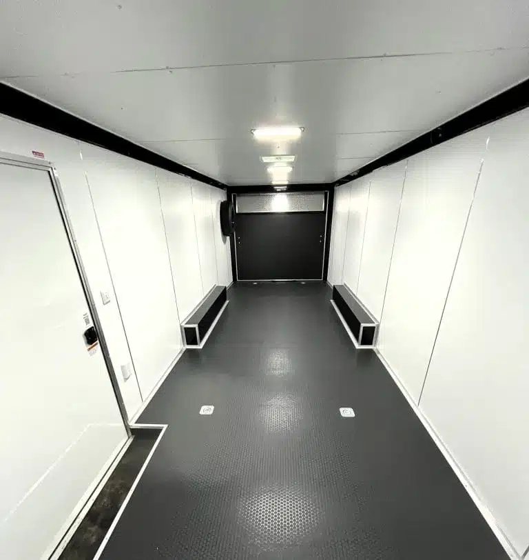 2025 Millennium Blaze 26 ft Car Hauler – Cabinets – Interior view looking toward the rear ramp door with black flooring and white walls