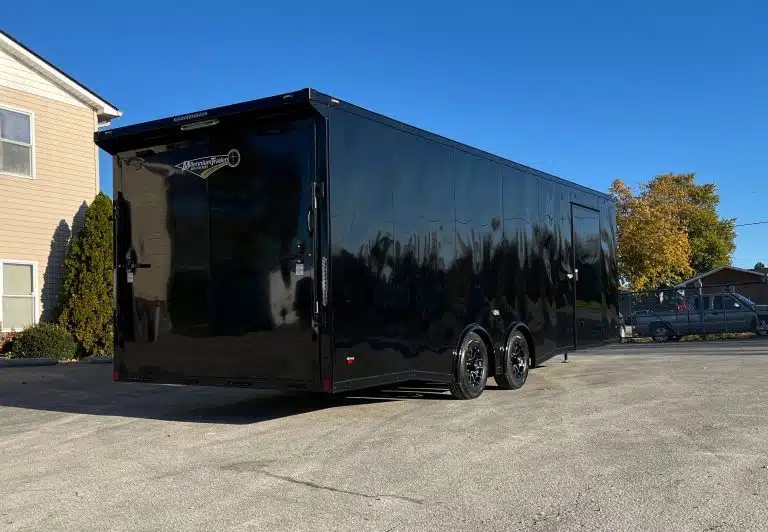 2025 Millennium 26 ft Car Hauler – Black-Out – Rear three-quarter view showing the back ramp door and side of the black trailer