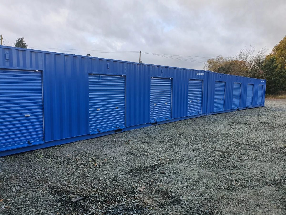 40ft High Cube Storage Container – Insulated, Plywood-Lined – Row of blue storage containers with closed roller shutter doors
