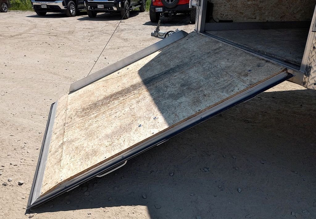 Mission Trailers 22 ft Snowmobile Trailer – 4-Place – Angle view of the wood-surfaced rear ramp door partially lowered to the ground