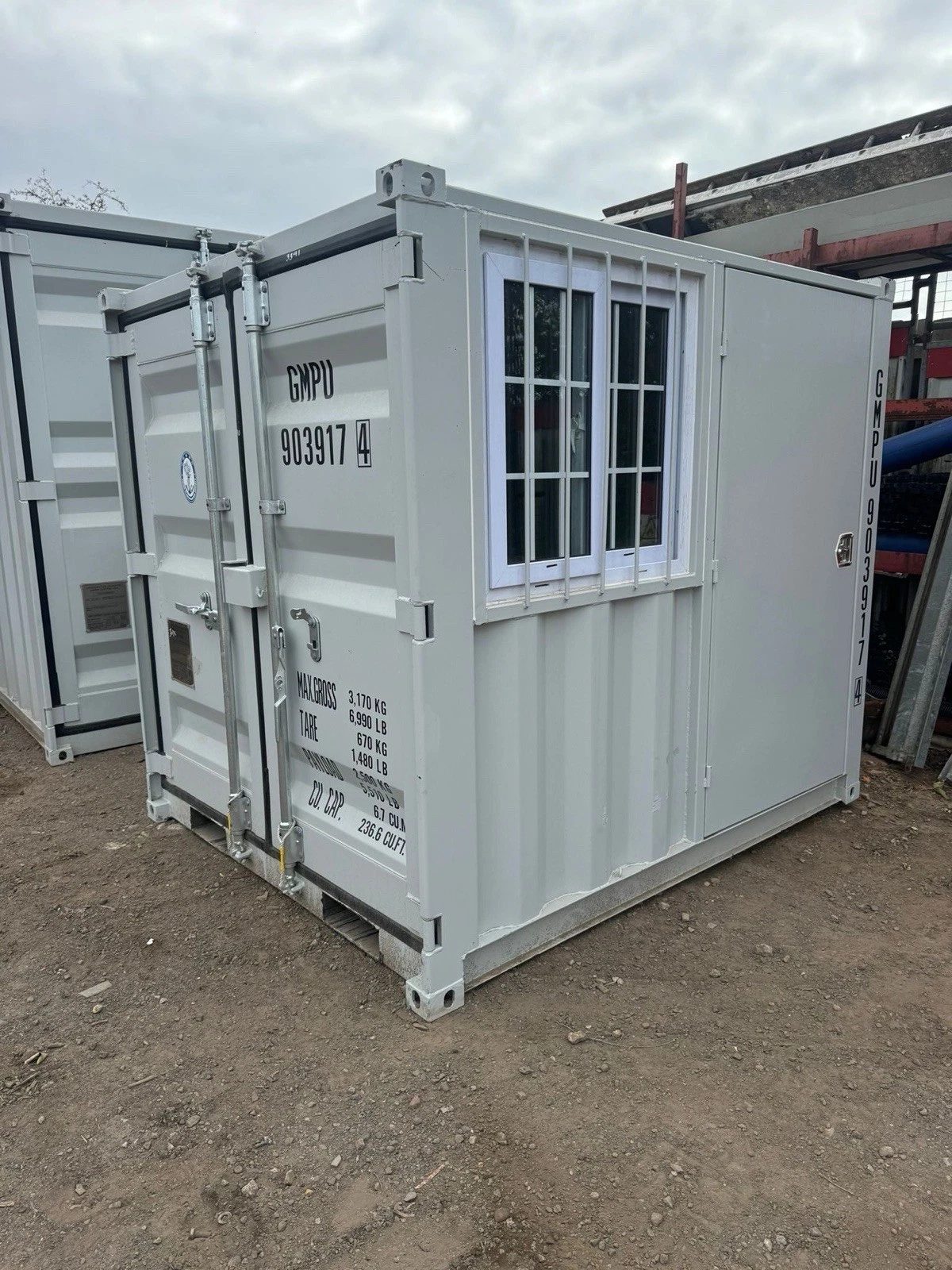 7ft New Storage Container – Window and Personnel Door – Three-quarter exterior with cargo doors, barred window and side door