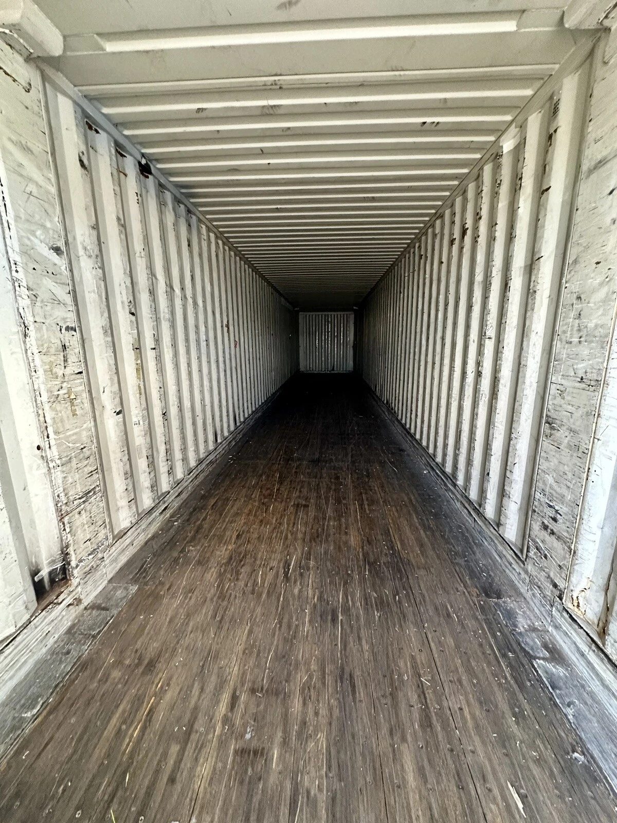 53ft High Cube Steel Shipping Container – Double End Doors – empty container interior with scuffed walls and wooden floor