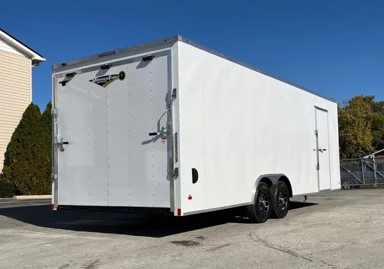 2026 Millennium 24 ft Car Hauler – White Hero – Rear view of white enclosed trailer showing the ramp door and side profile