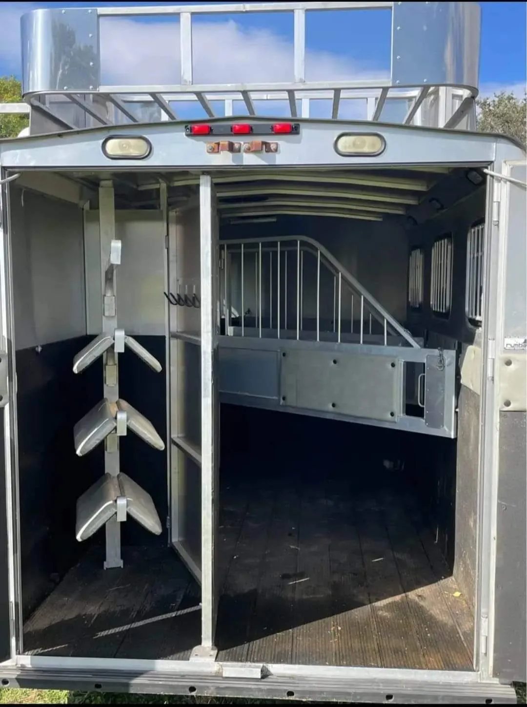 2005 Classic 16 ft 3 Horse Trailer – Dual Tack – View from the rear doors showing a swing-out saddle rack and interior