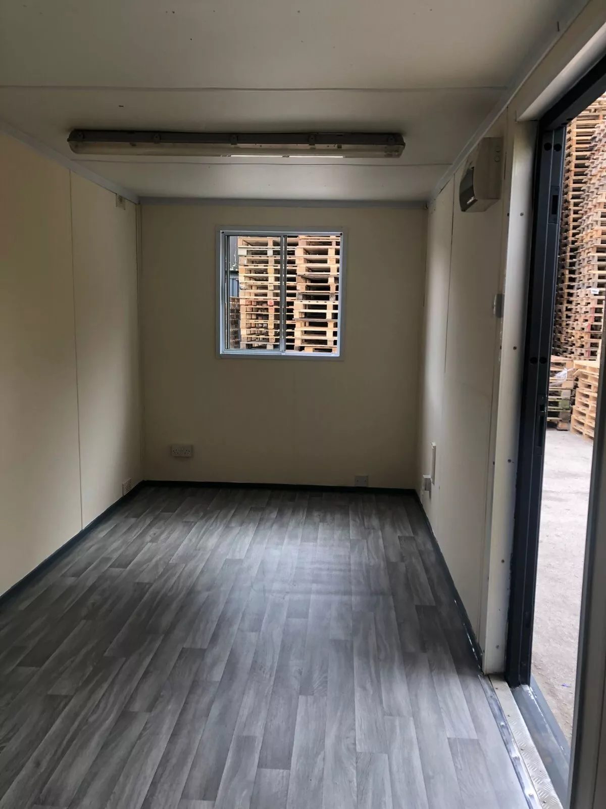 20ft Anti-Vandal Office Canteen – Insulated Steel Workspace – empty office interior with grey flooring and small window