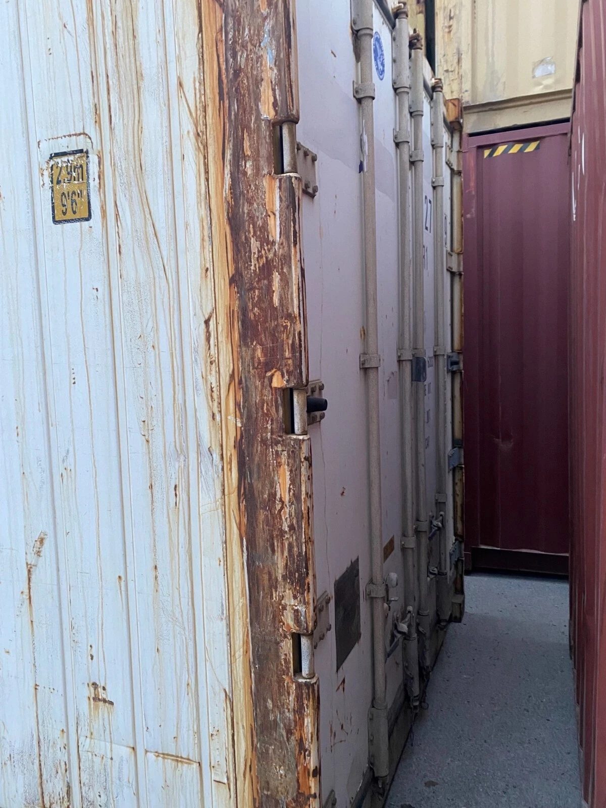 40ft Used Reefer Container – Non-Working Insulated Storage – rusted container doors and locking bars in narrow aisle
