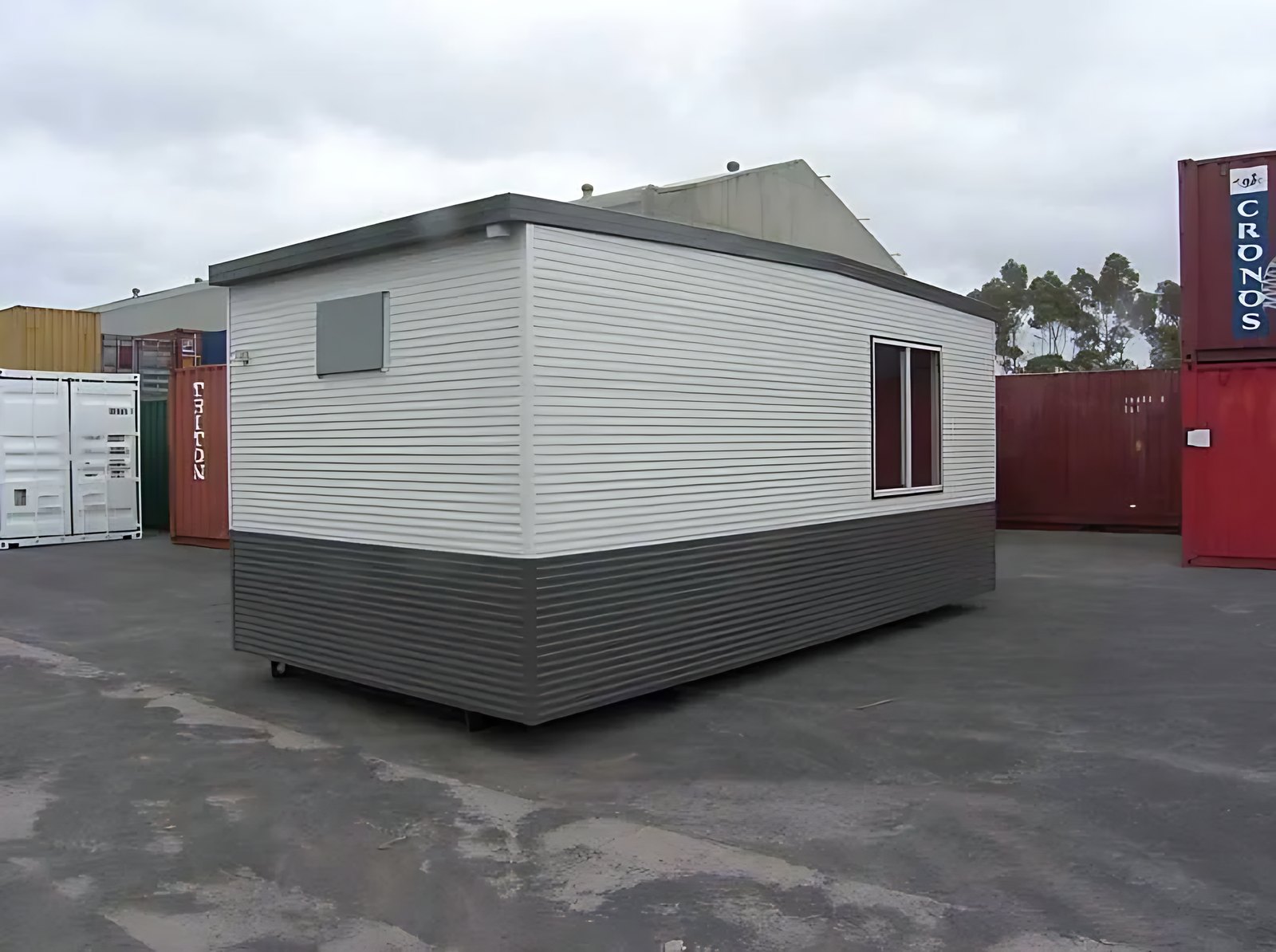 Custom Portable Steel Building – Office, Workshop or Storage – White and dark grey portable building with windows in a container yard