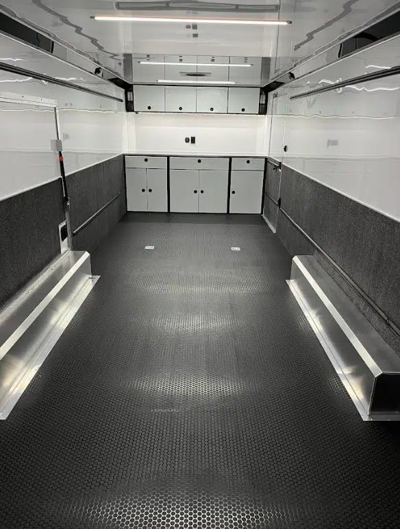 2026 ATC 28 ft Car Trailer – Premier Package – Interior view showing white cabinets and black textured floor with tie-downs