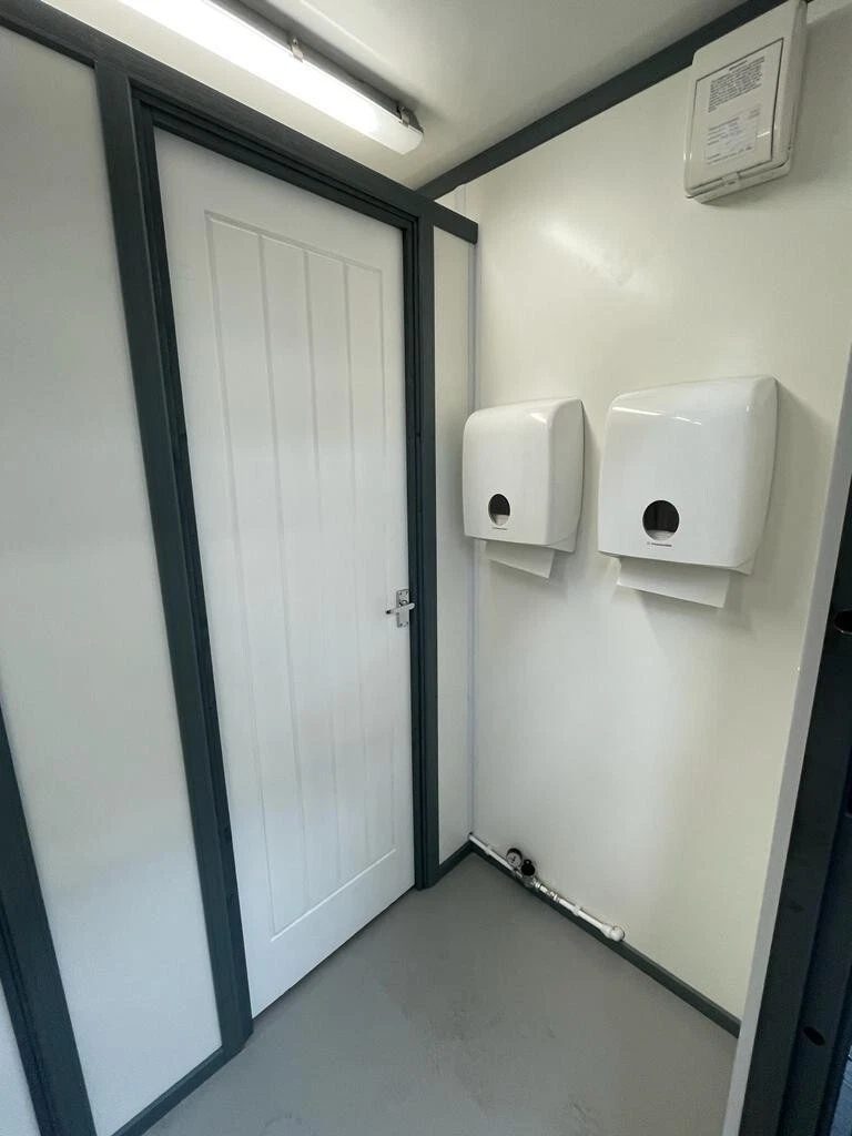 20ft Refurbished Container Toilet Block – Separate Compartments – toilet block interior with closed door and paper dispensers