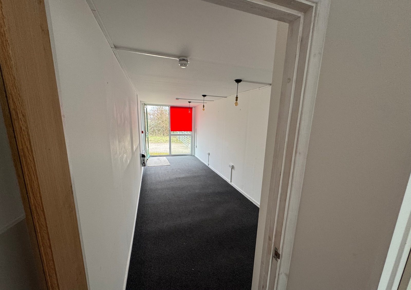 40ft Container Home – Two-Room Conversion – An interior shot showing the clean, white finish and modern carpet of a converted 40ft container home with two rooms