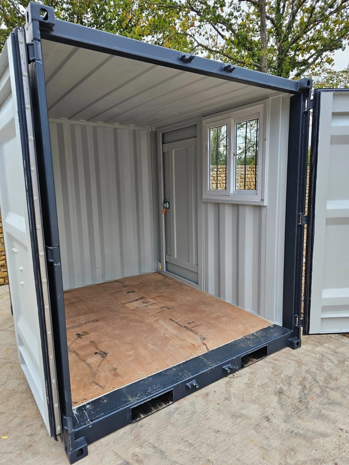 8ft New Shipping Container – Lockbox and Barred Windows – empty container interior with plywood floor and side window