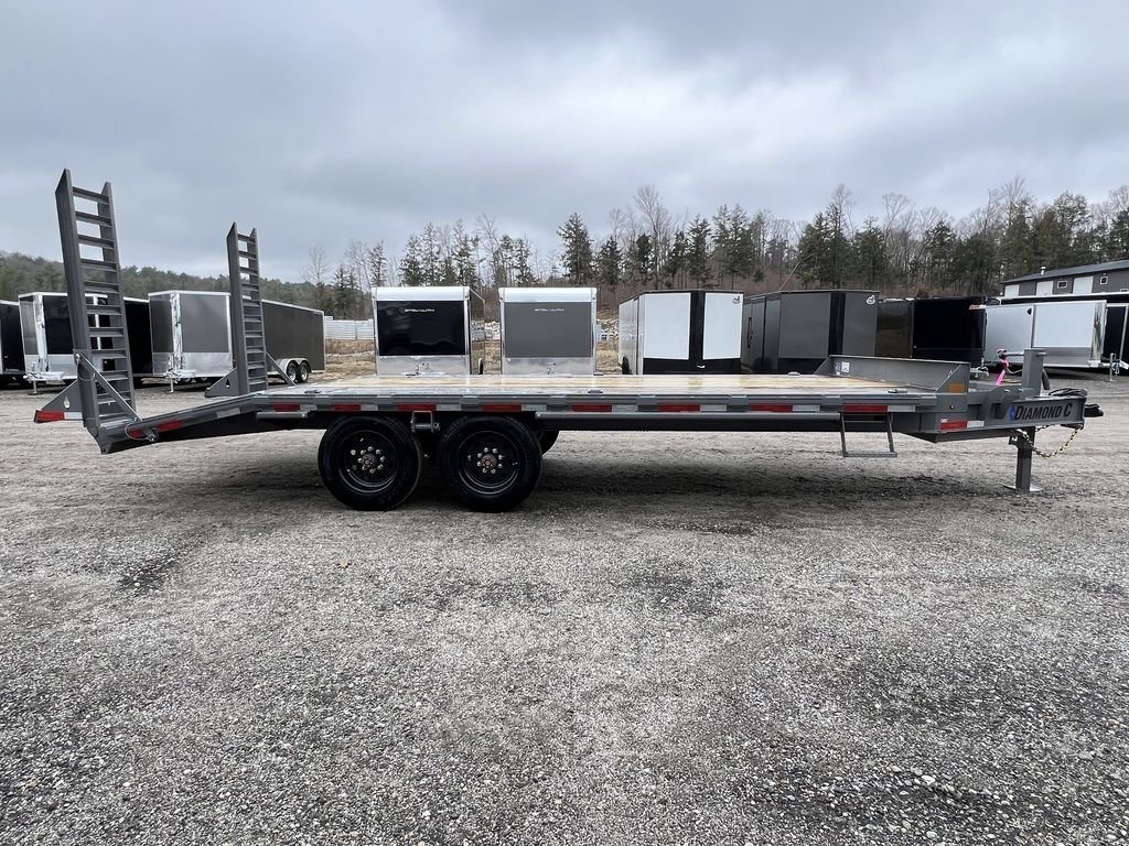 2024 Diamond C Deckover Equipment Trailer – Cement Gray – Full side profile view of the gray deckover trailer showing wheels and ramps