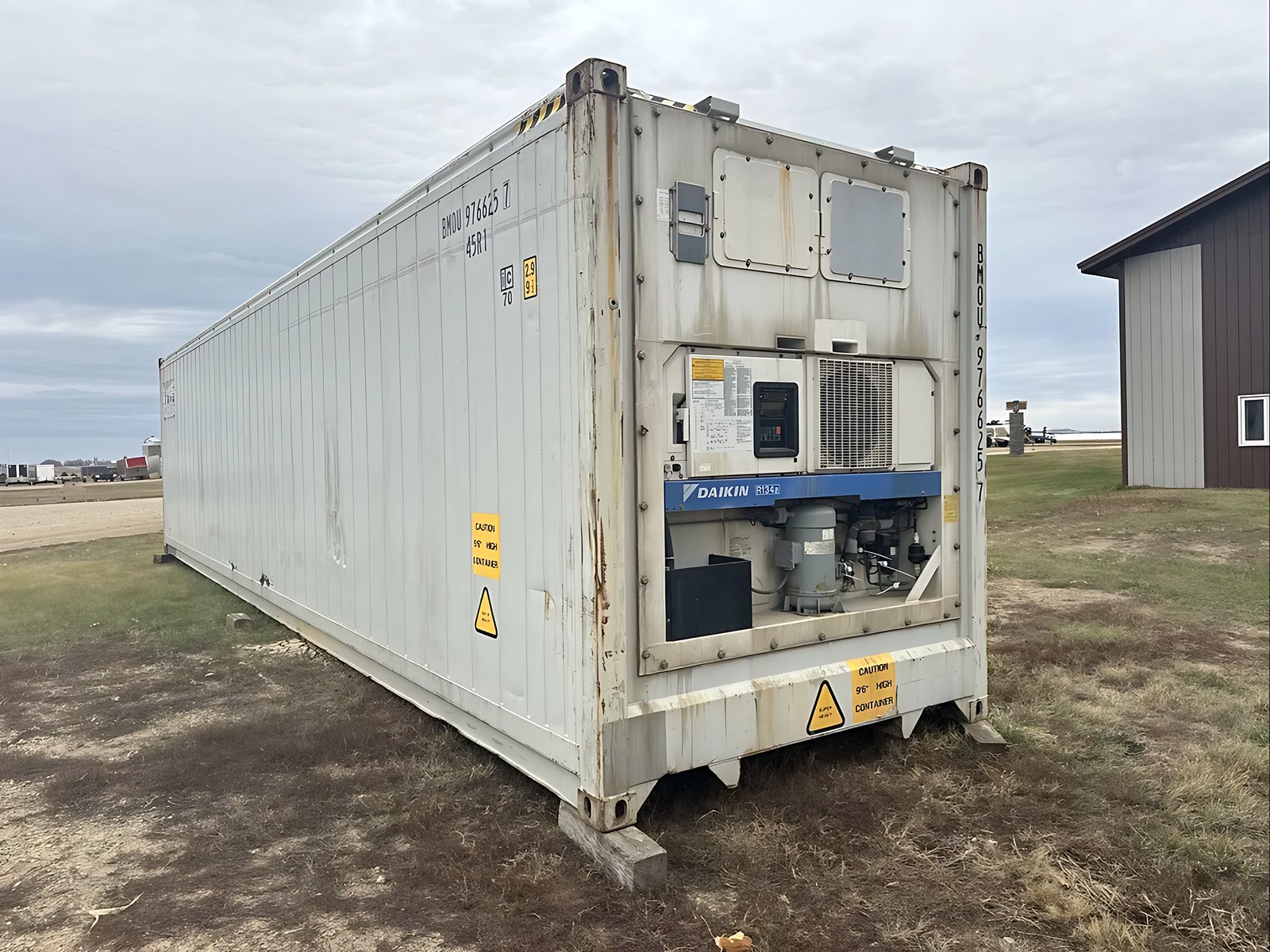 40ft Refrigerated Shipping Container – Daikin Cooling – Weathered white refrigerated container showing its long side and exposed cooling equipment outdoors