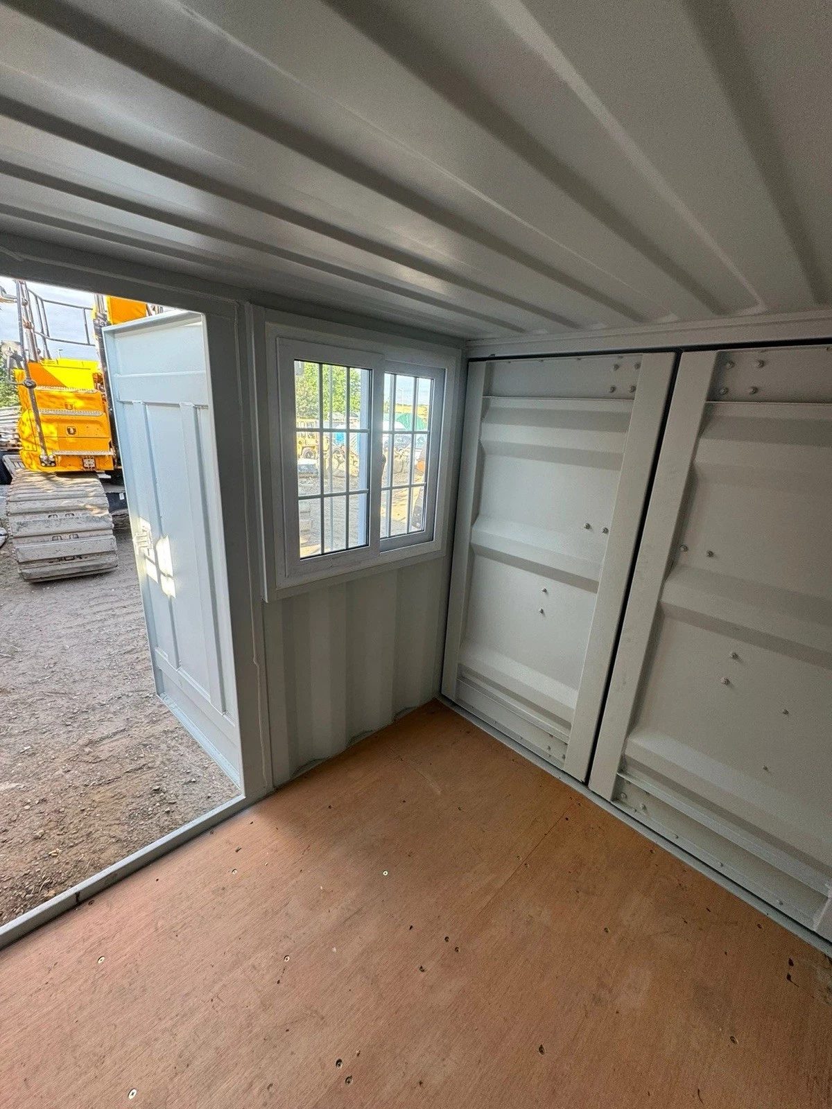7ft New Storage Container – Window and Personnel Door – empty container interior with barred window and open door