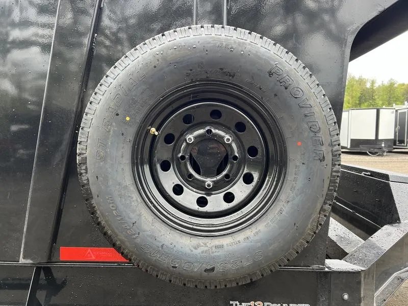 2024 RawMaxx 16 ft Dump Trailer – Tarp Kit – Side view of a spare tire mounted on the trailer side