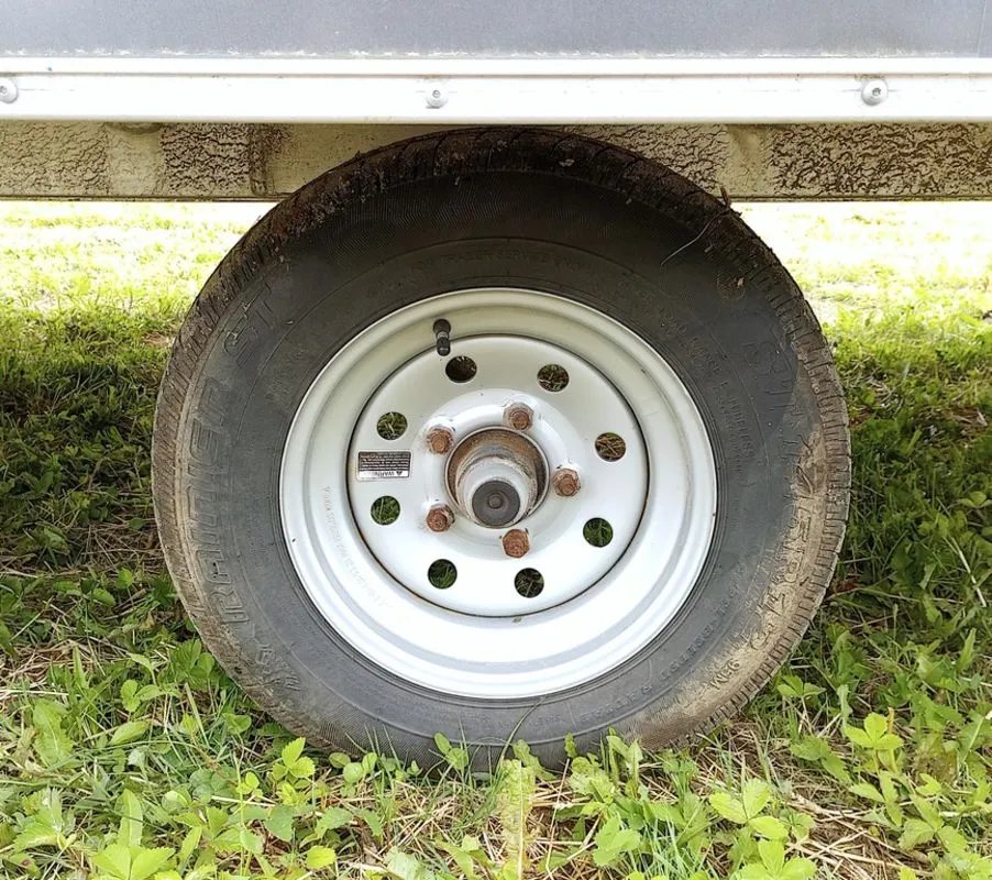 2022 Sno Pro Trailers Hybrid 2.0 – Charcoal Snowmobile Trailer – Close-up of a trailer wheel and tire on a white rim