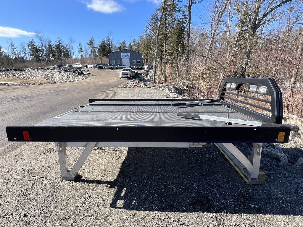 2023 Sno Pro 8 ft Sled Deck – Sliding Sides – Side view of the sled deck with a building in the background